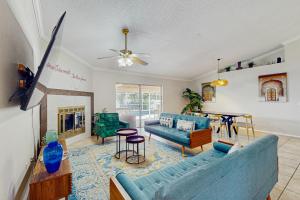 Una sala de estar con un sofá azul y una mesa. en The Boho Bungalow, en Orlando