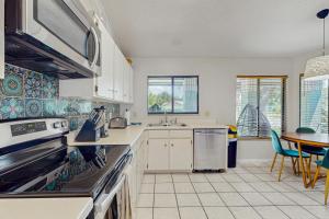 Una cocina con gabinetes blancos y una mesa. en The Boho Bungalow, en Orlando