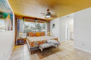 Un dormitorio con una cama y un ventilador de techo. en The Boho Bungalow, en Orlando
