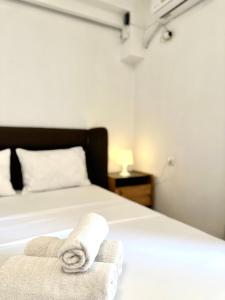een slaapkamer met een bed met handdoeken erop bij Larisa City Ap 5 with parking in Larisa