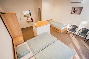 a room with two beds and a table and chairs at Ipoly Velo Vendégház in Slovenské Ďarmoty +4 photos
