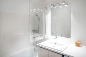 a white bathroom with a sink and a shower at Appartement Notre Dame in Capbreton +23 photos