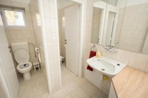 a white bathroom with a toilet and a sink at Ipoly Velo Vendégház in Slovenské Ďarmoty