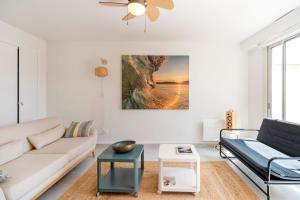 una sala de estar con un sofá y una mesa en Appartement Notre Dame, en Capbreton