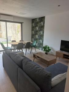 a living room with a couch and a table at L'Enclos de Nathalie et Jacques in Rieux-Minervois
