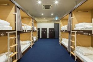 a room with a bunch of bunk beds at Hotel The Gate Kumamoto in Kumamoto