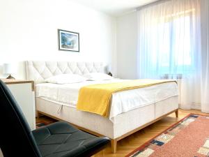 a bedroom with a bed and a chair and a window at Apartment Vito in Postira