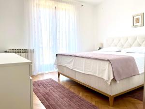 a bedroom with a large bed and a large window at Apartment Vito in Postira