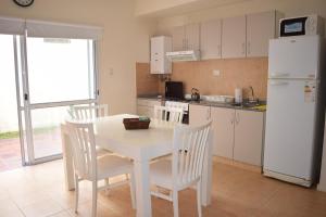 a kitchen with a table and chairs and a white refrigerator at Departamento céntrico Narapotí in Concepción del Uruguay
