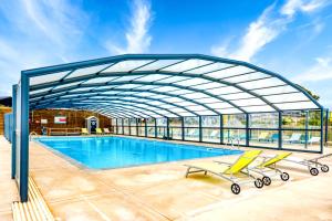 una grande piscina con tetto retrattile di Chalet de la Grenatière a Pomérols