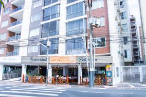 巴拉奈里奥-坎布里乌Apartamento no centro, bem localizado, na praia的街道拐角处的建筑物,有商店