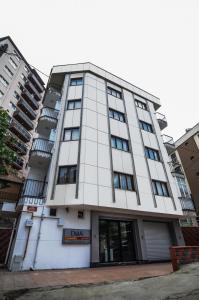 un edificio blanco alto con un letrero. en Doa Apartment, en Trabzon