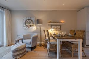 une salle à manger avec une table et des chaises dans l'établissement Möwennest, à Tinnum 16 autres photos