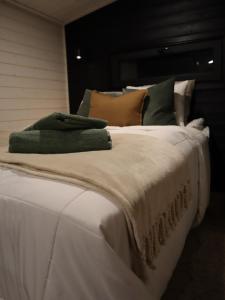 Una gran cama blanca con almohadas encima. en Little Aurora Cabin, en Rovaniemi