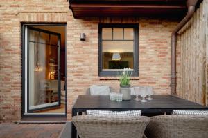 d'une terrasse avec une table et des chaises sur un mur en briques. dans l'établissement Möwennest, à Tinnum