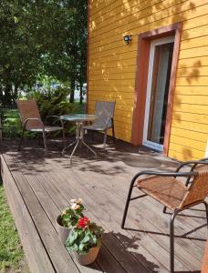 a patio with three chairs and a table and a plant at Muraka Apartement in Pärnu