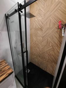 une cabine de douche avec un mur en bois dans l'établissement Apartament Jagiellońska, à Bydgoszcz 61 autres photos