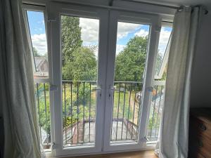 een kamer met glazen schuifdeuren en een balkon bij Chalgrove Way in Caversham