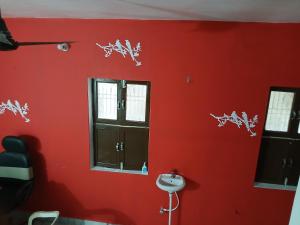バラナシにあるKashvi Home Stayの窓と洗面台のある赤い壁のバスルーム