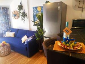 a blue couch in a living room with a bowl of fruit on a table at Casa MACON BLUE in Caleta De Fuste