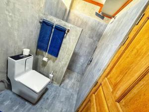 Un baño con inodoro, ventana y puerta. en Dive and Sleep - All Inclusive Diving Guesthouse - 3 Dives per day, en Maamigili