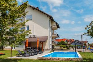a building with a swimming pool in front of a house at Kuća za odmor Dugo Selo M&A in Dugo Selo