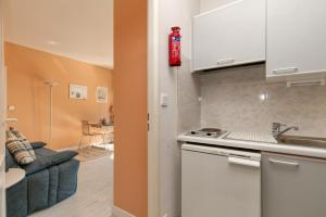 a kitchen with a red fire extinguisher on the wall at Studio Cosy Au Bord De L'eau in Le Pouliguen +15 photos