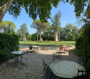 a group of tables and chairs with umbrellas in a park at Domaine de Bellevue CHAMBRE D'HÔTES in Beaumes-de-Venise +23 photos