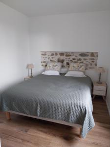 a bedroom with a large bed with two pillows at La Petite Ferme Aux Prés in Saint-Germain-Lespinasse