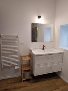a bathroom with a white sink and a mirror at La Petite Ferme Aux Prés in Saint-Germain-Lespinasse +8 photos