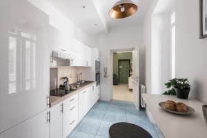 eine Küche mit weißen Schränken und einem Tisch mit einem Teller Brot in der Unterkunft The Best Rent - Bright flat near San Pietro in Rom