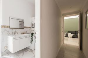 ein weißes Badezimmer mit Waschbecken und Spiegel in der Unterkunft The Best Rent - Bright flat near San Pietro in Rom + 24 Fotos