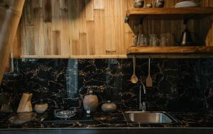 a kitchen counter with a sink and wooden cabinets at Umah Bali Kuno Villa New in Tampaksiring +18 photos