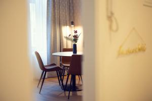a dining room table with chairs and a vase with flowers at LeonArt Living 24 in Graz
