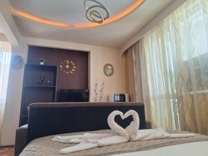 a bedroom with a bed with two swans forming a heart at Lily Aparts in Varna City
