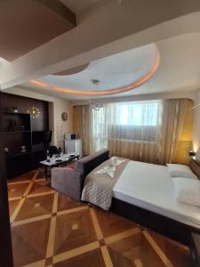 une chambre avec un grand lit et un canapé dans l'établissement Lily Aparts, à Varna