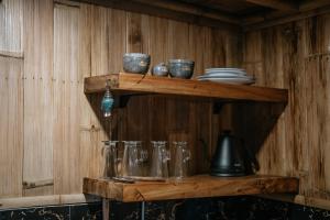 a wooden shelf with bowls and utensils on it at Umah Bali Kuno Villa New in Tampaksiring