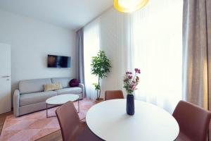 a living room with a table and a couch at LeonArt Living 24 in Graz