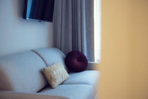 a pillow sitting on a couch next to a window at LeonArt Living 24 in Graz +23 photos