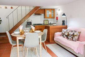 Una sala de estar con una mesa y un sofá rosa. en Quinta da Chanca, en Paredes de Coura