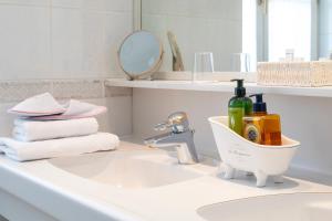 Łazienka z umywalką, dwiema butelkami mydła i ręcznikami w obiekcie Hotel Schwalbe w Wiedniu