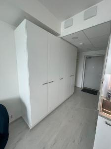 pusty pokój z białymi szafkami i sufitem w obiekcie RD Apartments Oy - Areenan Sydän w mieście Tampere