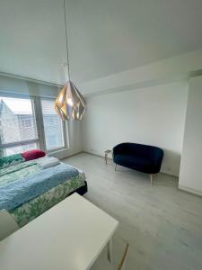 sypialnia z łóżkiem i niebieskim krzesłem w obiekcie RD Apartments Oy - Areenan Sydän w mieście Tampere