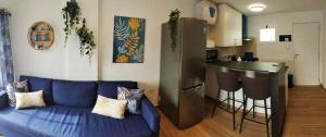 a living room with a blue couch and a kitchen at Casa MACON BLUE in Caleta De Fuste