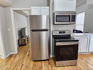 a kitchen with a stainless steel refrigerator and microwave at Room for rent in apartment Hartford, CT in Hartford