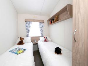 two beds in a small room with stuffed animals on them at Nature's Nook - Billing Aquadrome in Northampton +32 photos