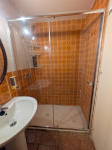 a shower with a glass door next to a sink at Nueva 6 in Algeciras