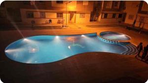 a large swimming pool in a building at night at Beau appartement à saidia in Saïdia