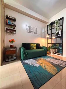 a living room with a green couch and a rug at SLY Staycation at Shore Residences Mall of Asia in Manila