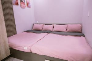 a bed in a room with pink sheets and pillows at TP HOUSE - Homestay Kim Long Huế in Thôn Dương Xuân Hạ